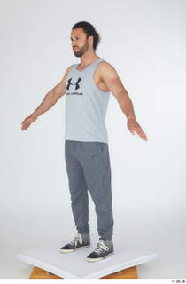 Simeon A poses dressed grey joggers grey sneakers grey tank…